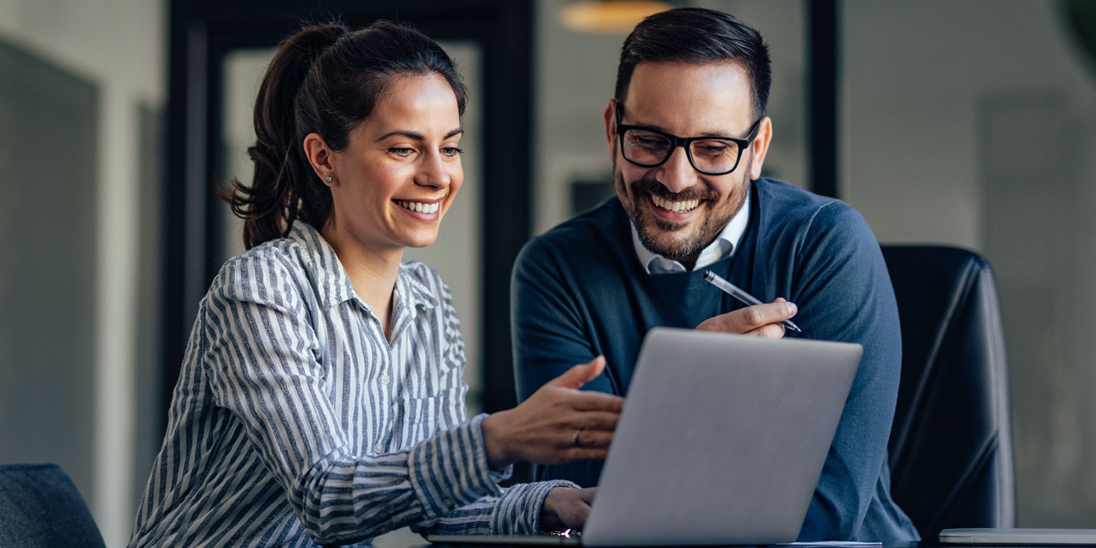two workers looking at a laptop