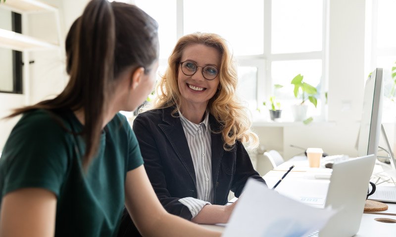 Middle-aged office worker talking to a young adult