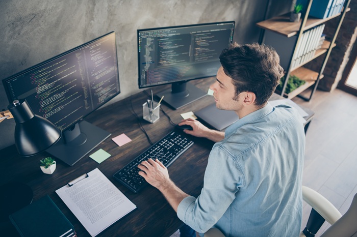 An office worker looking at 2 screens